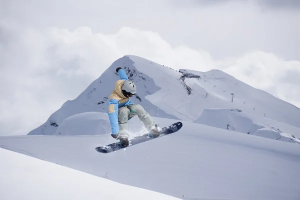 Repülő snowboardos a hegyekben. Extrém sport. — Stock Fotó