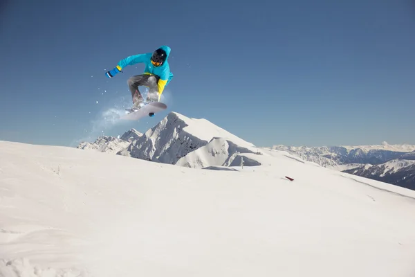 Um snowboarder voador nas montanhas. Desporto extremo. — Fotografia de Stock