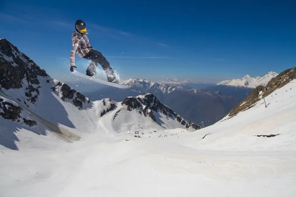 Repülő snowboardos a hegyekben. Extrém sport. — Stock Fotó