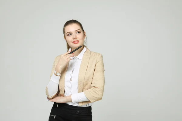 Jonge zakenvrouw denken, pen in de hand houden — Stockfoto