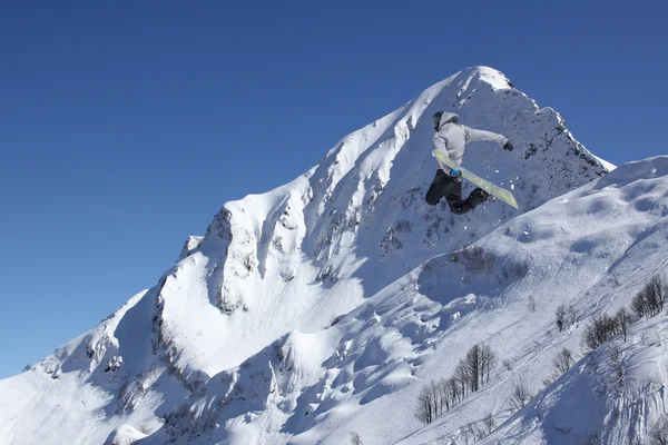 Vliegende snowboarder op de bergen. Extreme sport. — Stockfoto