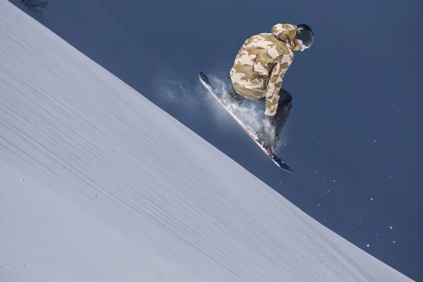 Um snowboarder voador nas montanhas. Desporto extremo. — Fotografia de Stock