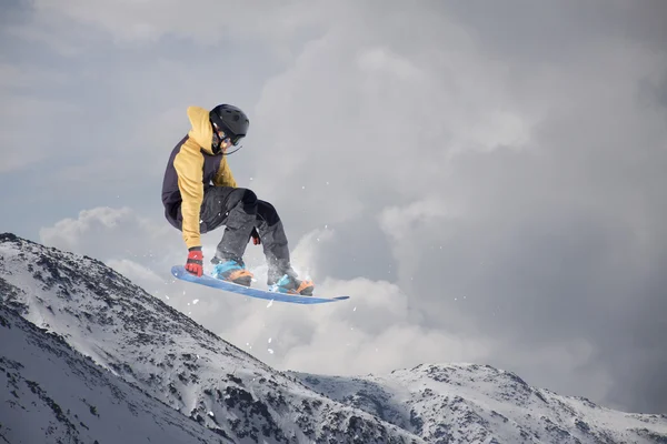 Um snowboarder voador nas montanhas. Desporto extremo. — Fotografia de Stock