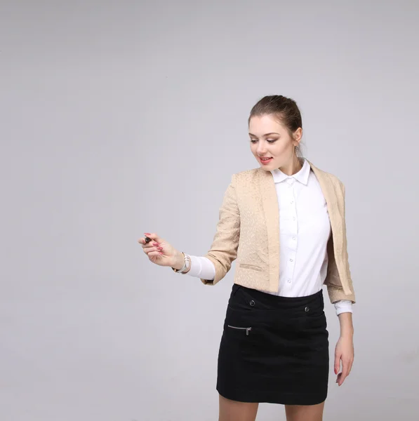 Mujer joven con pluma sobre fondo gris — Foto de Stock