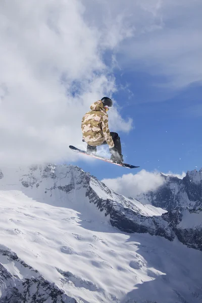 Flygande snowboardåkare på fjället. Extrem sport. — Stockfoto