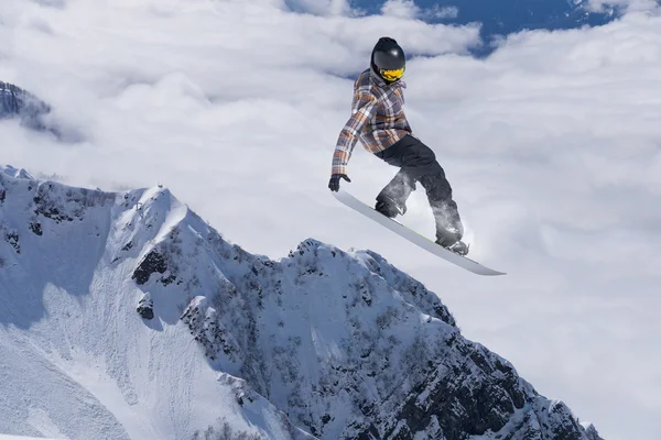 Um snowboarder voador nas montanhas. Desporto extremo. — Fotografia de Stock