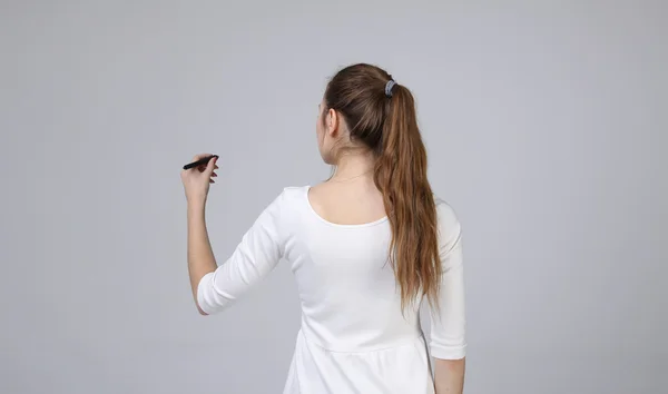 Jonge vrouw met pen op een grijze achtergrond — Stockfoto