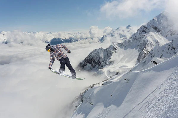 Um snowboarder voador nas montanhas. Desporto extremo. — Fotografia de Stock