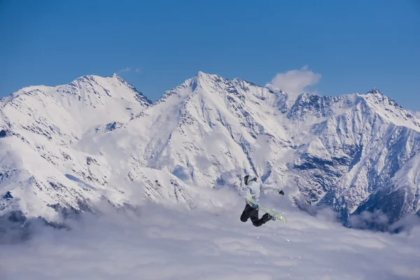 Um snowboarder voador nas montanhas. Desporto extremo. — Fotografia de Stock