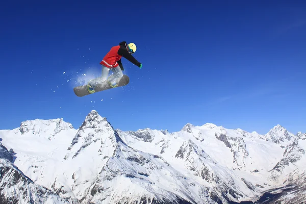 Vliegende snowboarder op de bergen. Extreme sport. — Stockfoto