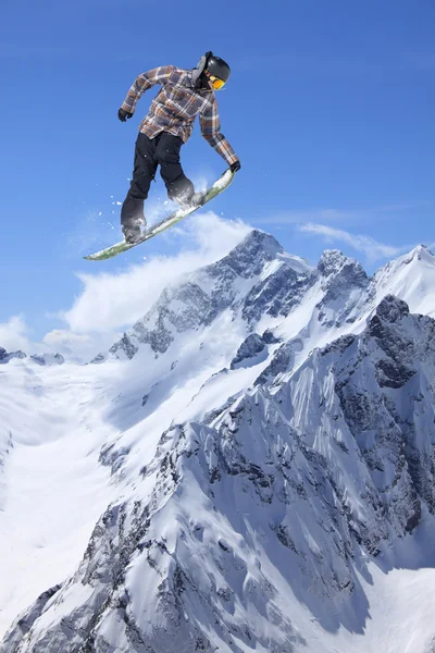 Repülő snowboardos a hegyekben. Extrém sport. — Stock Fotó