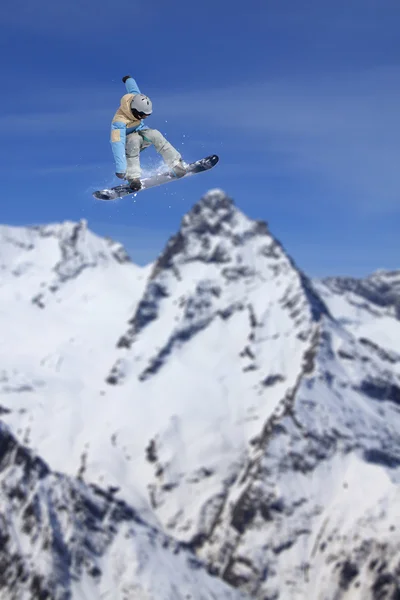 Vliegende snowboarder op de bergen. Extreme sport. — Stockfoto