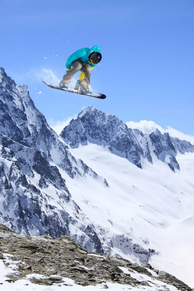 Flygande snowboardåkare på fjället. Extrem sport. — Stockfoto