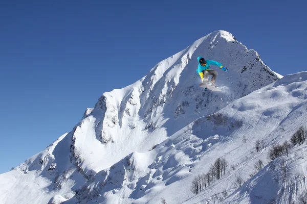 Flygande snowboardåkare på fjället. Extrem sport. — Stockfoto