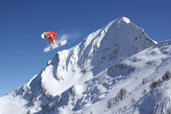 Vliegende snowboarder op de bergen. Extreme sport. — Stockfoto