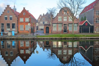 Reflections of historic and colorful houses along Nieuwe Haven street, Edam, North Holland, Netherlands