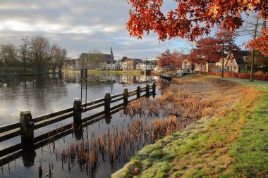 Tarihsel şehir merkezi Weesp, Amsterdam, Kuzey Hollanda, Hollanda 'nın doğusunda yer alan küçük bir kasaba, arka planda Vecht kanalı ve Gotik St. Laurenskerk kilisesi üzerinde yansımaları vardır.
