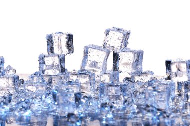 Beyaz zemin üzerinde şeffaf soğuk buz küpleri.
