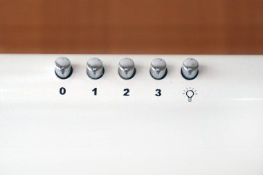 Kahverengi arka planda fırın kaputunda başlıkları olan metal düğmeler