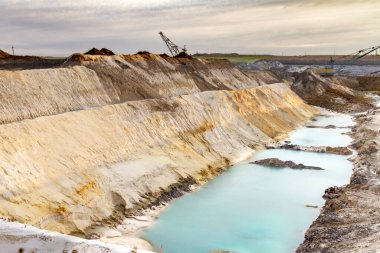 Yürüyen bir kılavuz kazıcı kilden bir çukurda aşırı yük taşır. Zaporizhia bölgesi, Ukrayna. Ocak 2015