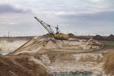 Bir kılavuz ipi kazıcısı kil ocağında mineral birikintileri geliştirir. Zaporozhye bölgesi, Ukrayna. Kasım 2017