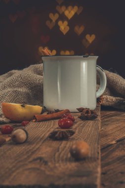 Beyaz bir retro fincanda şarap ya da gluhwein. Parlak şenlikli arka planda baharatlar var.