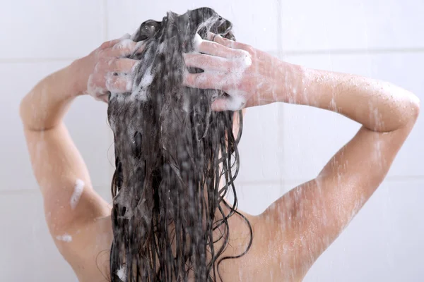 Frau wäscht Kopf mit Shampoo — Stockfoto