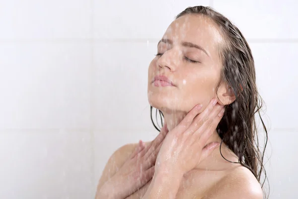 Une femme debout à la douche Photo De Stock