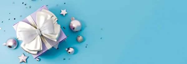 Mutlu yıllar ya da hediye kutulu Noel afişi. Mavi arka planda altın kurdeleli parlak mavi hediye kutusu, 3 boyutlu. — Stok fotoğraf