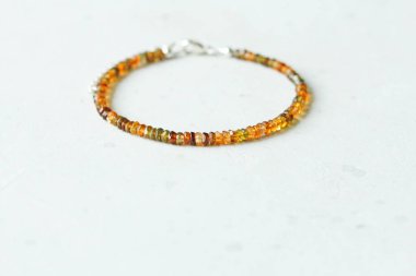 Tourmaline bileziği. Doğal Tourmaline taşından yapılmış bilezik. Doğal taşlardan yapılmış bilezik. El yapımı mücevherler. Hafif modern arkaplanda el yapımı bilezikler.