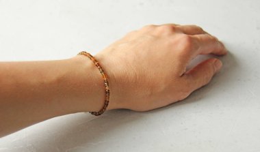 Tourmaline bileziği. Doğal bir Tourmaline taşından yapılmış bir bilezik. Doğal taşlardan yapılmış bilezik. El yapımı mücevherler. Hafif modern arkaplanda el yapımı bilezikler.