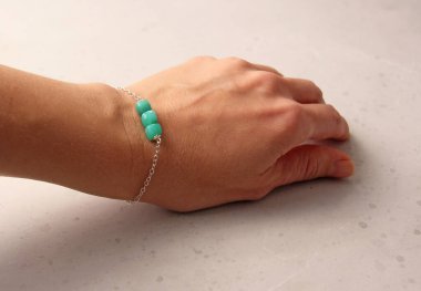 Krisopraz bileziği. Doğal taştan yapılmış Chrysoprase bilekliği. Doğal taşlardan yapılmış bilezik. El yapımı mücevherler. Hafif modern arkaplanda el yapımı bilezikler.