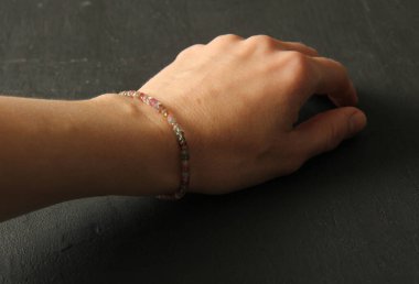 Tourmaline bileziği. Doğal Tourmaline taşından yapılmış bilezik. Doğal taşlardan yapılmış bilezik. El yapımı mücevherler. Hafif modern arkaplanda el yapımı bilezikler.