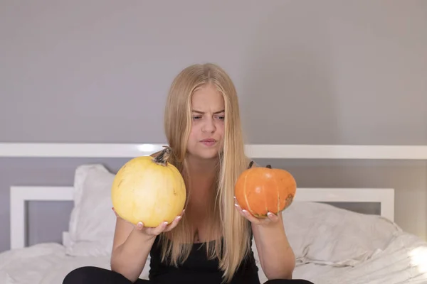 Hermosa rubia con dos calabazas en dormitorio blanco. concepto de Halloween — Foto de Stock