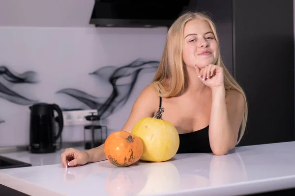 Hermosa rubia feliz con dos calabazas en cocina gris. concepto de Halloween — Foto de Stock