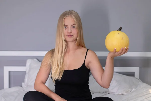 Hermosa rubia con calabaza en dormitorio blanco. concepto de Halloween — Foto de Stock