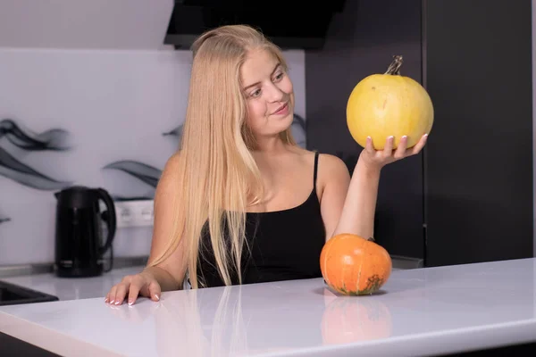 Hermosa rubia feliz con dos calabazas en cocina gris. concepto de Halloween — Foto de Stock