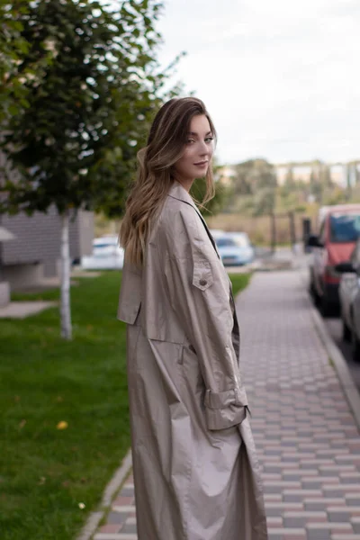 Attraktiv smal ung brunett i fashionabla trenchcoat och svart klänning — Stockfoto