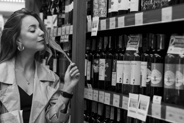 Сексуальная привлекательная женщина в винном магазине среди полок с вином. черно-белое фото. мягкий фокус — стоковое фото