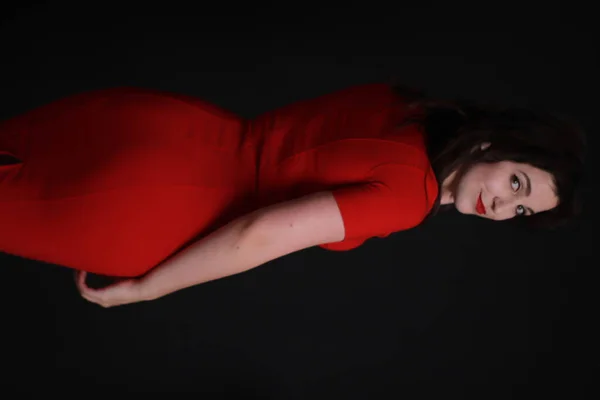 性感迷人的黑发，穿着红色紧身衣，与黑色背景隔离。工作室拍摄。情妇. — 图库照片