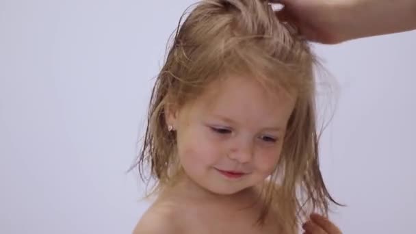 头发干燥过程。妈妈们用可爱快乐的金发小女儿的吹风机擦干头发。头发护理。为人父母FullHD视频 — 图库视频影像
