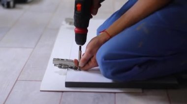 Daire yenileme işlemi. Fettler ön cepheye elektrikli tornavidayla çivi çakıyor. Tanımlanamayan adamlar. Tadilat, onarım. Tam HD görüntüler