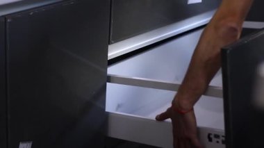 Daire yenileme işlemi. Fettler dolaba yeni bir çekmece koyuyor. Tanımlanamayan adamlar. Tadilat, onarım. Tam HD görüntüler.