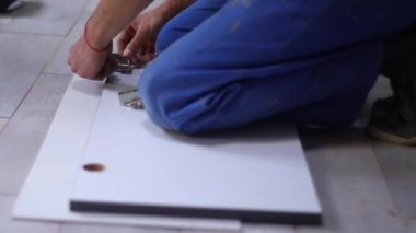 Daire yenileme işlemi. Fettler ön cepheye kapı menteşeleri koyar. Tanımlanamayan adamlar. Tadilat, onarım. Tam HD görüntüler.