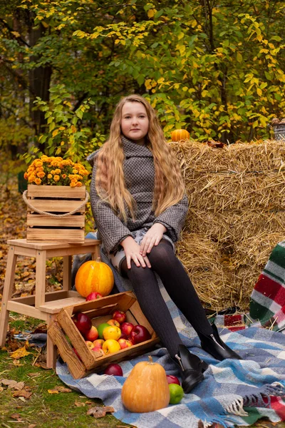 秋の要素の装飾の近くに灰色のコートのかわいいブルネットの10代の女の子 カボチャ リンゴ 干し草 美人秋 — ストック写真