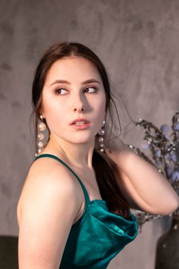 Çatı katındaki kafede zarif yeşil akuamarin elbiseli çekici esmer kadın. Güzel, şehvetli bir kız. Boşluğu kopyala.