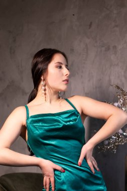 Çatı katındaki kafede zarif yeşil akuamarin elbiseli çekici esmer kadın. Güzel, şehvetli bir kız. Boşluğu kopyala.