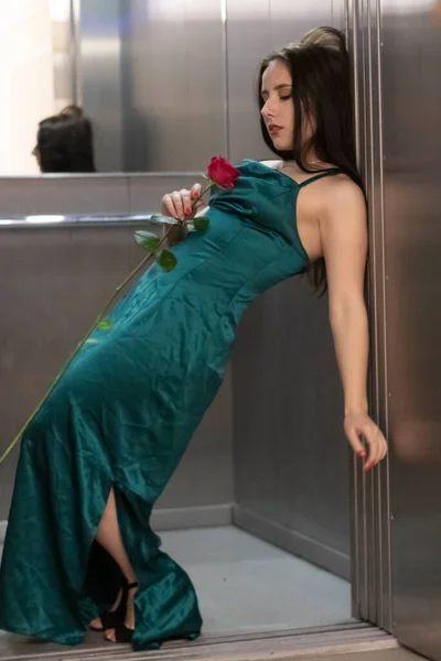 Сексуальная Уверенная Брюнетка Элегантном Аквамариновом Платье Красной Розой Сером Лифте — стоковое фото