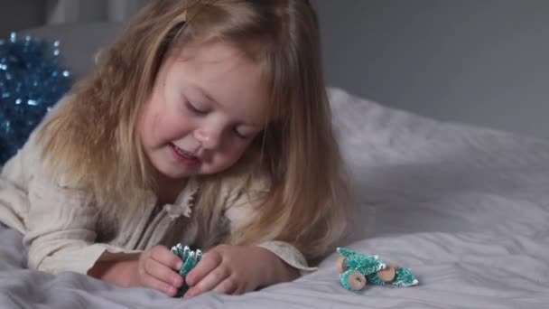 Pretty Little Girl Playing Little Christmas Trees Lying Bed Gray — Stock Video