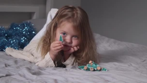 Bonita Niña Jugando Con Pequeños Árboles Navidad Acostados Cama Dormitorio — Vídeos de Stock